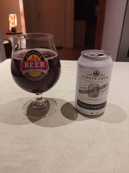 Glas med mörk öl och en burk Ranger Creek Bourbon Barrel Imperial Coffee Ale på ett bord.