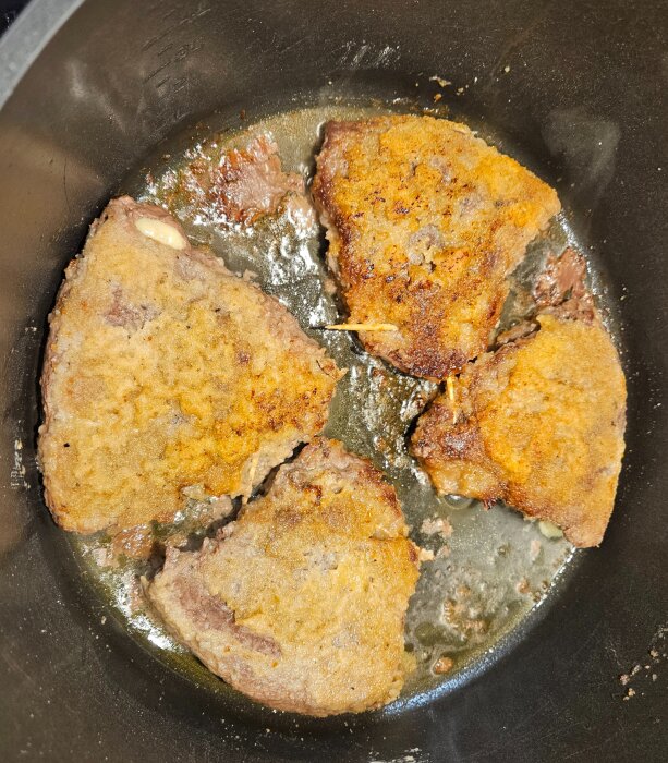 Stekta bitar av dubbelpanerad Cordon Bleu i panna med gyllene yta.