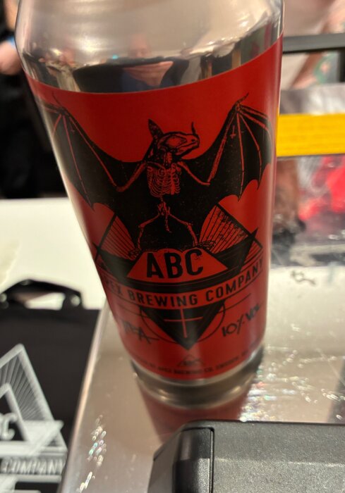 Närbild av etiketten på en aluminiumburk från ABC Brewing Company, med en svart fladdermusdesign mot en röd bakgrund.