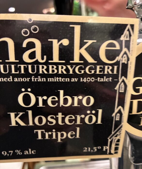 Etikett på en flaska Örebro Klosteröl Tripel från Närke Kulturbryggeri, 9,7% alkoholhalt.