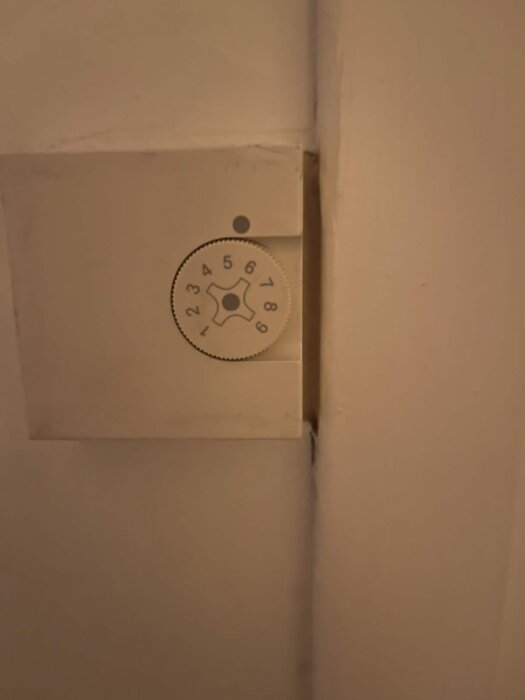 Rund ratt med siffror 1 till 9 i en dosainstallation, inställd på 5.5, används för att justera inställningar för bergvärmepump.