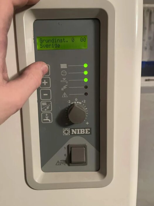 Kontrollpanel för Nibe bergvärmepump med temperaturreglage och blinkande symbol, inställd på 5.5 av 9, display visar "Grundinst. 0 00 Sverige".