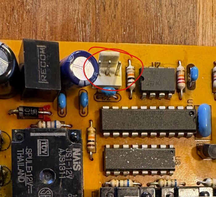 Elektronikkretskort med markerad tom kontaktplats, kondensatorer och motstånd omgivna av kretskomponenter.