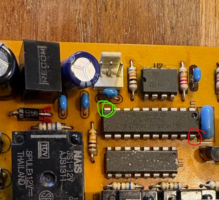 Kretskort med elektroniska komponenter, komponent markerad med grön cirkel; textdiskussion om jordanslutning.