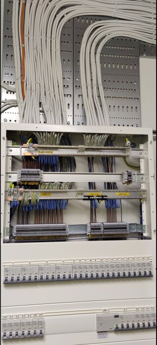 Elcentral med ordnade kablar och säkringar, del av ett större elinstallationsprojekt.
