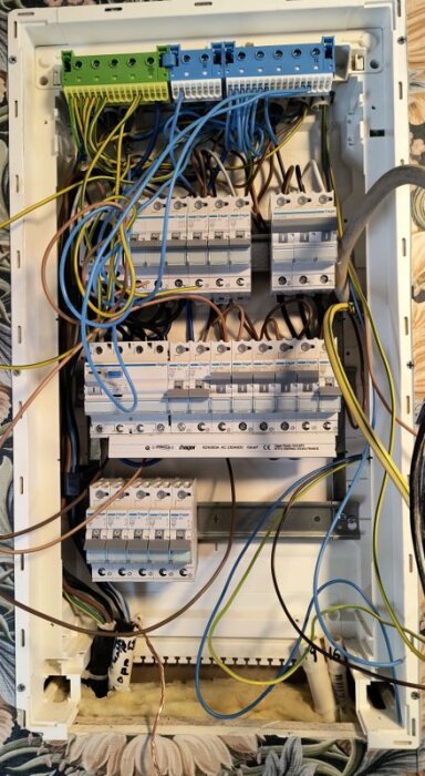 Elcentral i byggskede med exponerade kablar och säkringar, del av byggprojekt för temporär elinstallation.
