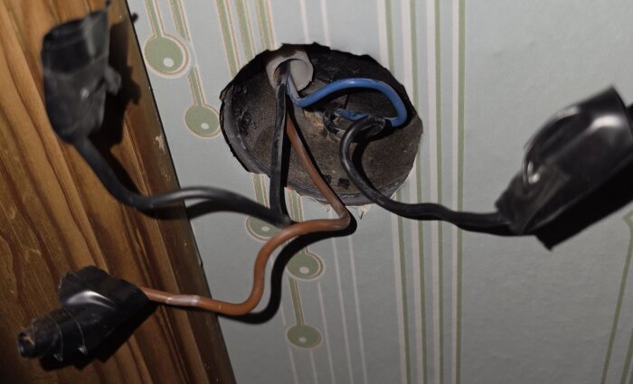 Överväg att byta ut gammal och troligtvis farlig elinstallation med synliga kablar och sladdar i en vägg med tapet.