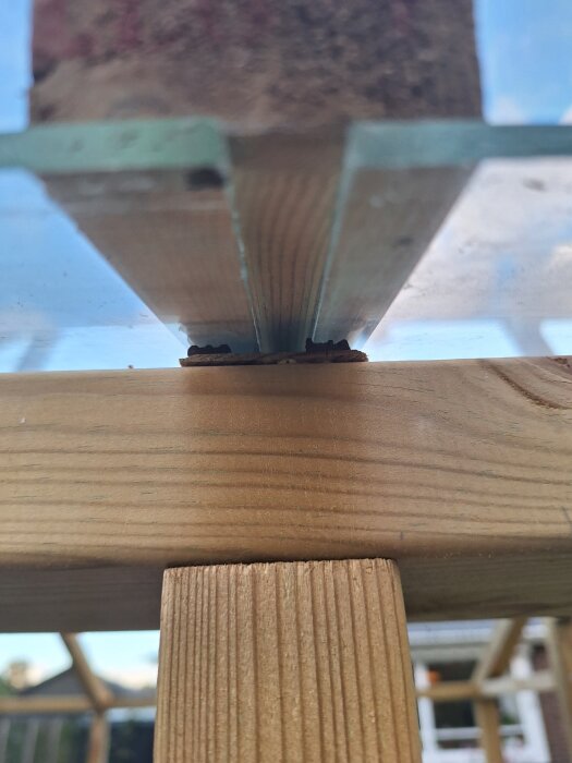 Trästruktur med glas skivat vertikalt och förseglat med tätningslist, byggprojekt som visar fönsterinstallation på tak.