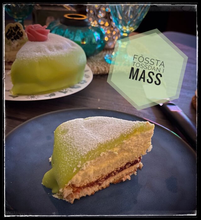 Prinsesstårta med marsipanöverdrag och text "Fössta Tossdan i Mass" i bakgrunden, dekorerad med ros.