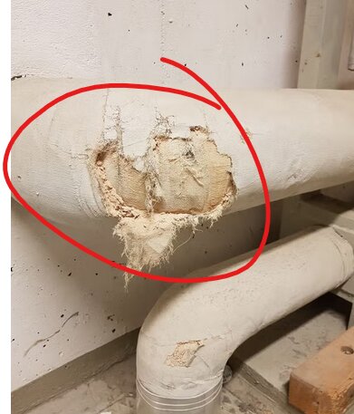 Skadad äldre isolering på rör, möjligtvis innehållande stenull där materialet är exponerat, omgiven av ett markerat område.