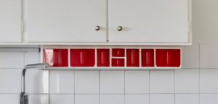 Gammaldags köksskåp med vita dörrar och inbyggd kryddhylla med röda glasbehållare, renoveringen av 50-talskök diskuteras.