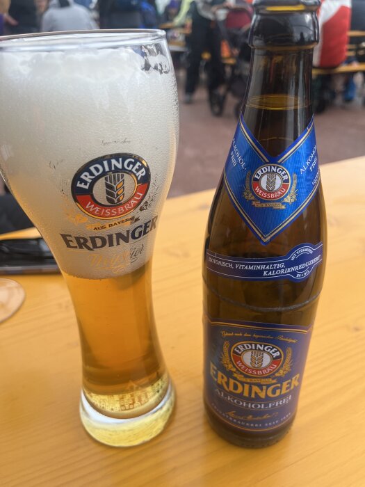 En Erdinger-ölglas och flaska alkoholfri öl på ett bord.