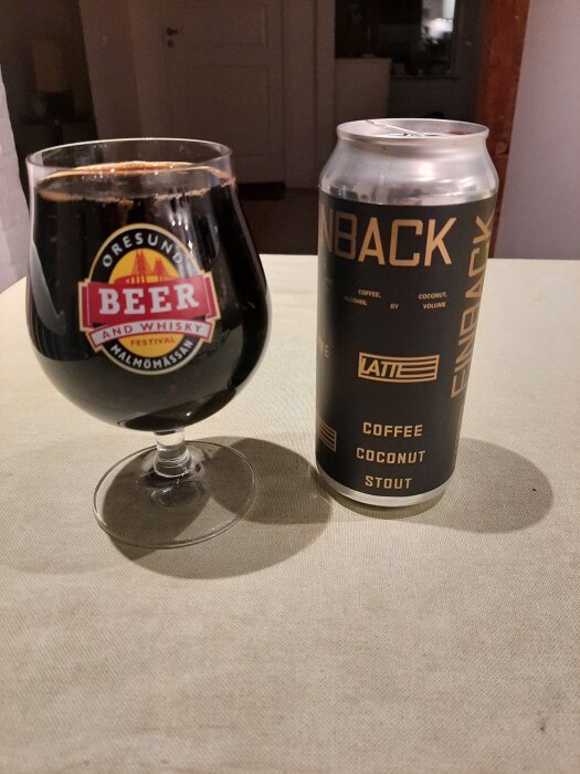 Ett glas mörk stoutöl med en ölburk bredvid, märkt "Finback Coffee Coconut Stout".