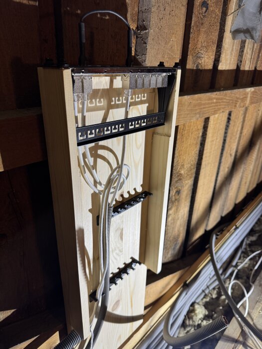 Trärack byggt för nätverk, med fästa kablar och slangar. Inkluderar en 10" panel och Elektroskutts Klicks på trävägg i östra husdelen.