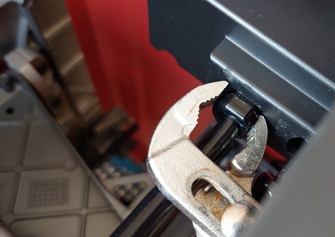 Polygriptång som används för att lossa klips på en bordssågs kabelanslutning.
