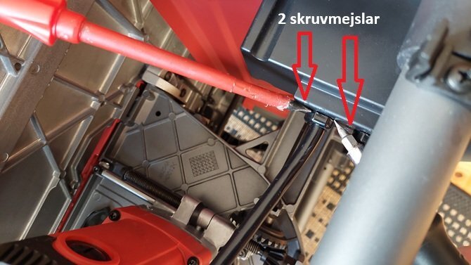 Bilden visar en maskindel där två skruvmejslar används för att lossa klipsen på kablarna under installation av mjukstart.