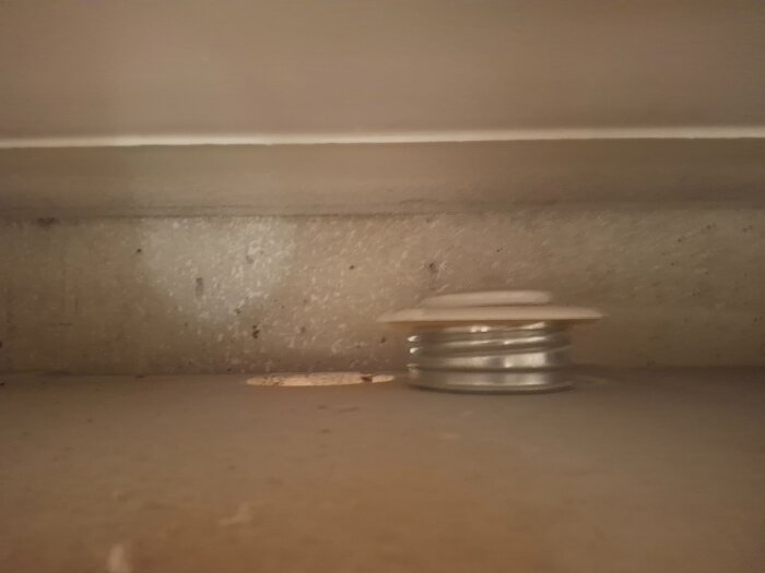 Ventil i en träbox på en konsols överdel, plats för röranslutning.