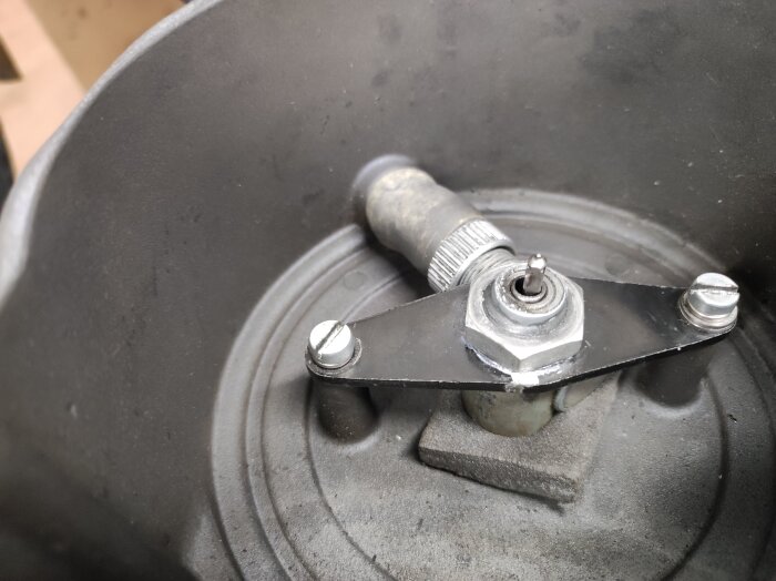 Närbild av mopeddel med svänghjulsmutter och monterad tvättpolett som använts för att reparera varvräknargivare.