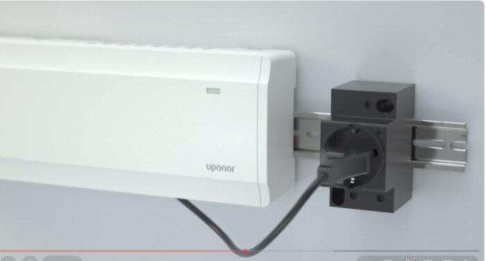 Uponor fördelarskåp med elkabel ansluten till ett eluttag på en DIN-skena i ett inbyggt installationsskåp.