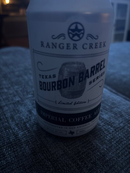 Burk med etikett för Ranger Creek Texas Bourbon Barrel Series Imperial Coffee Ale på grå bakgrund.