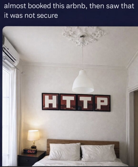 Sovrumsinteriör med dubbelsäng, kuddar, nattduksbord med lampa och väggdekoration som stavar "HTTP" i fyra ramar ovanför sängen.
