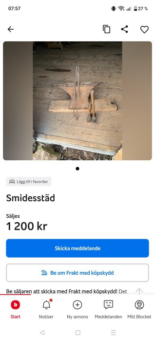 Gammaldags smidesstäd i metall med två verktyg placerade på ett trädäck.