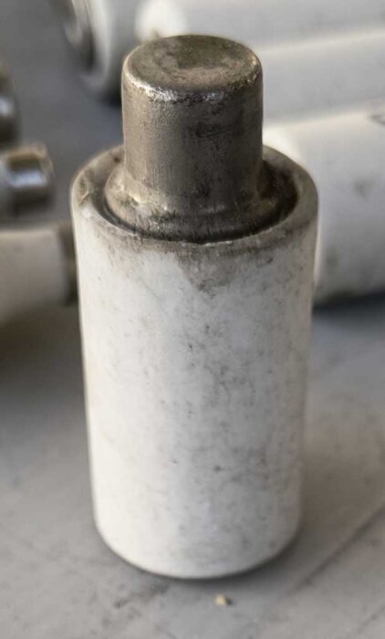 Gammal vit porslinssäkring av typen D2 med metalltopp, av märket IFÖ, 20A, del av en samling med olika utseende och utföranden genom åren.