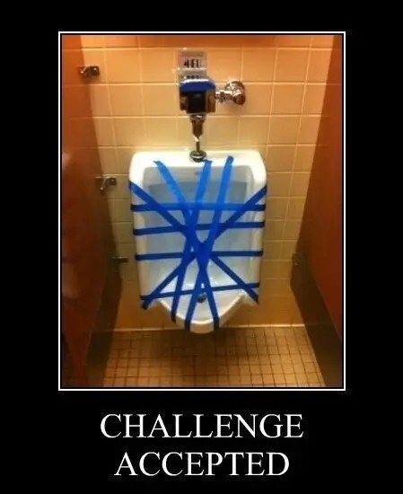 A urinal is covered with blue tape in a restroom, with the caption "Challenge Accepted" below.