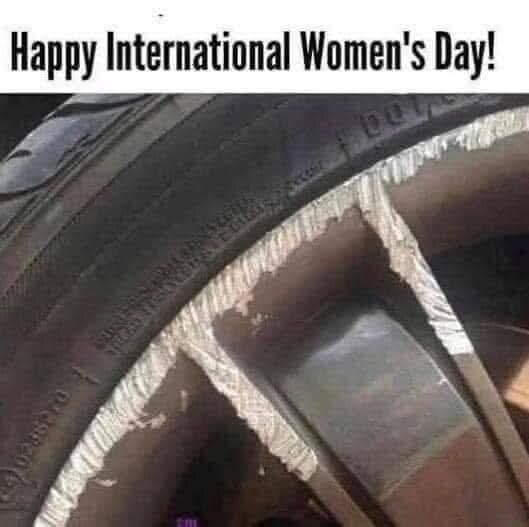 Närbild på en bilfälg med skador och texten "Happy International Women's Day" ovanför.