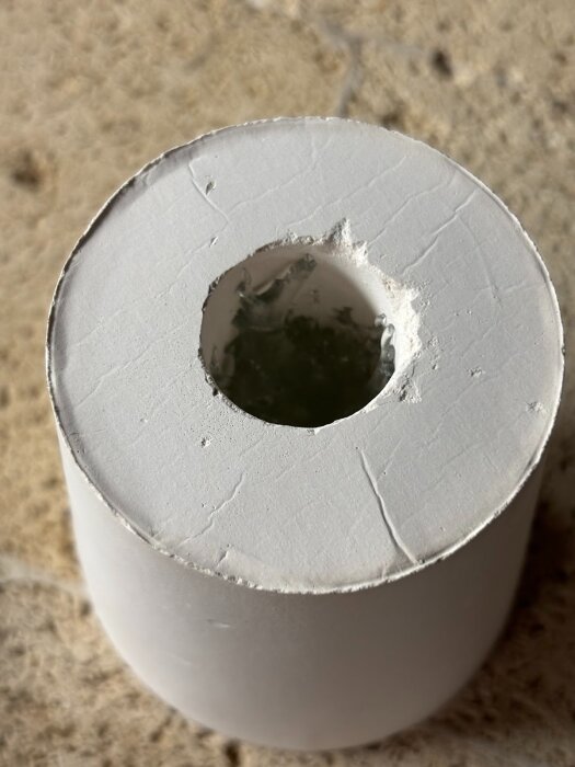 Gipsform med ett centralt hål innehållande glas, tagen ovanifrån.
