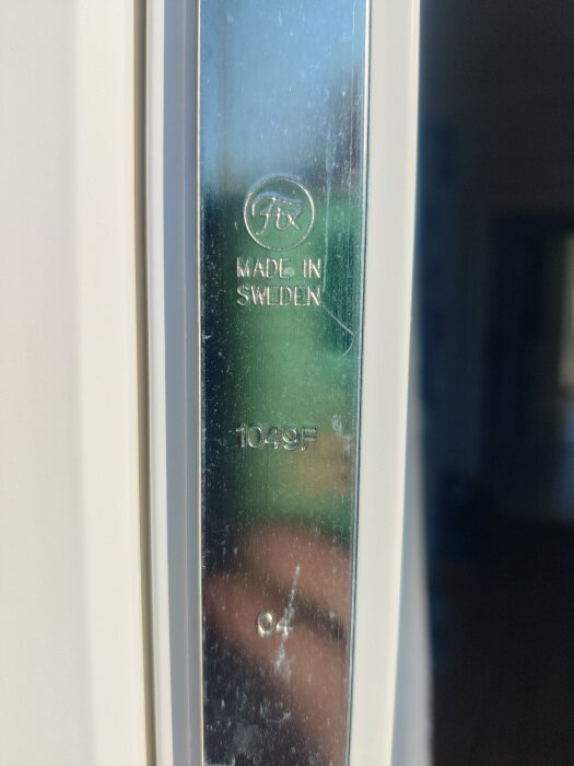 Alt-texter för bilden: Närbild på en spanjolett märkt "Fix Made in Sweden 1049F" monterad på en altandörr utan synligt handtag på utsidan.