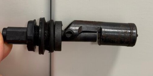 Vattennivåsensor mot ljusgrå bakgrund, hålls upp av en hand.
