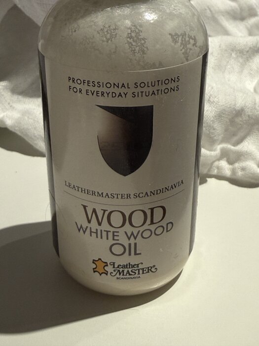 Flaska med vitpigmenterad träolja "Wood White Wood Oil" från Leather Master Scandinavia, används vid behandling av ekfaner i kök.