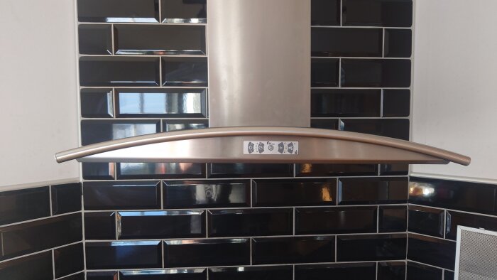 Thermex köksfläkt framför svart kakelvägg, centralt placerad med fyra symboler på frontpanel.