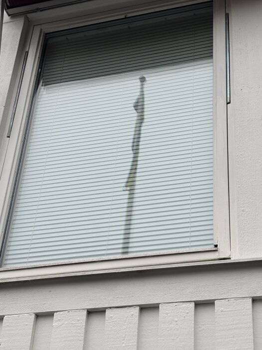 Fönster med fönsterbläck och persienner, husfasad från 90-talet.