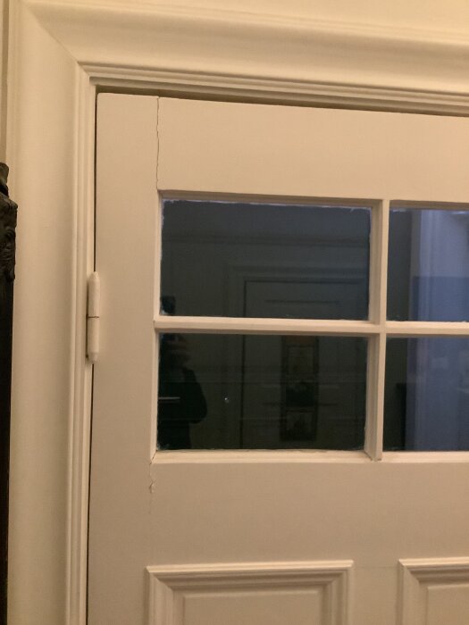 Äldre dörr med fönstersektioner som hänger lågt på gångjärn, där låset inte passar i karmen. Gångjärnen är övermålade, vilket hindrar justering.