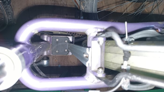 Bild på undersidan av en Ecoride-cykel med fokus på batterifästet monterat mellan cykelramens rör.