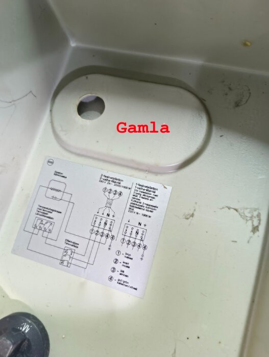 Gammal varmvattenberedare med kopplingsschema synligt, etikett med texten "Gamla" markerar området.
