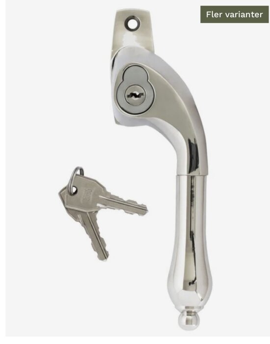 Silverfärgat fönsterhandtag med inbyggt lås och två nycklar bredvid.