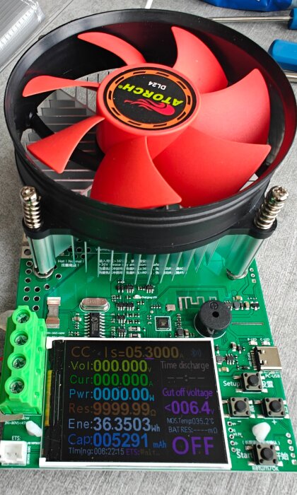 En elektronisk last med en röd fläkt och en digital display som visar mätvärden i färgglada siffror.