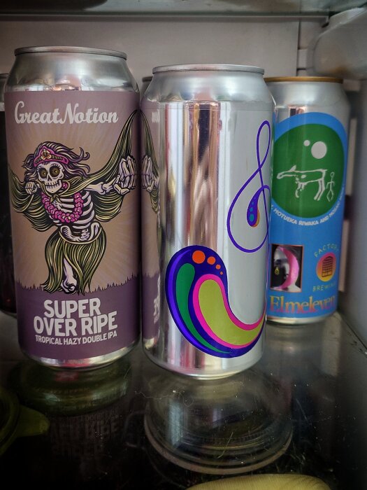Ölburkar i ett kylskåp med olika färgglada etiketter, inklusive en med texten "Super Over Ripe".