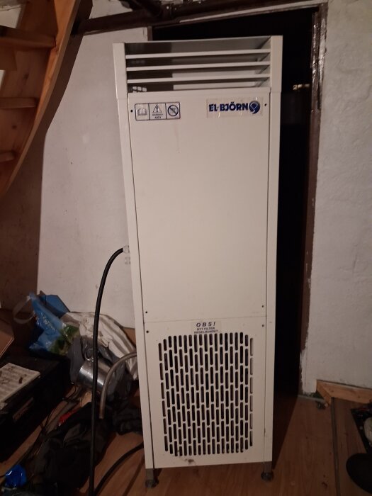 Avfuktare av märket El-Björn i en källare, vita paneler med ventilationsgaller, hoppas uppställd för att säljas.
