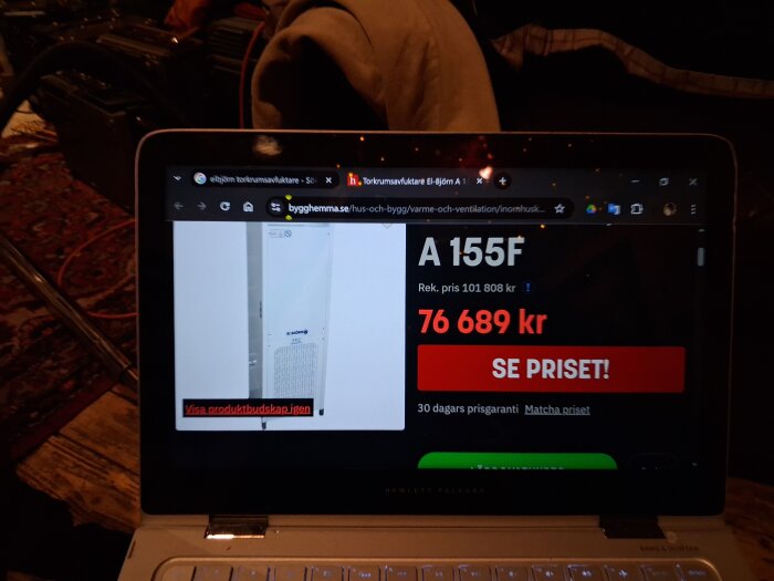 En bild på en datorskärm som visar en El-Björn torkavfuktare A 155F från en webbplats med nuvarande pris 76 689 kr och "SE PRISET" knapp.