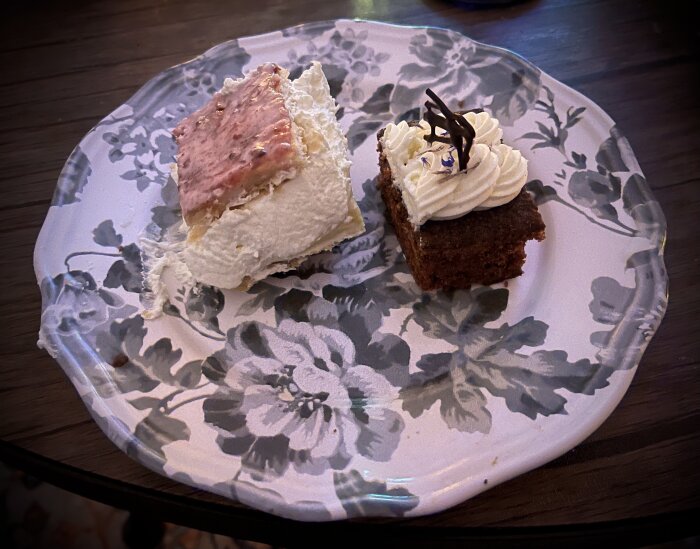 Två bakverk på blommönstrad tallrik; en Napoleonbakelse med grädde och en morotskaka med frosting och chokladdekoration.