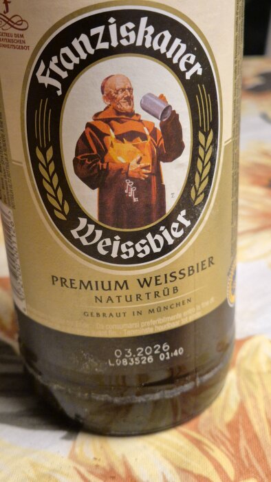 Flaska med etikett för Franziskaner Weissbier, visar en munk med ölsejdel.