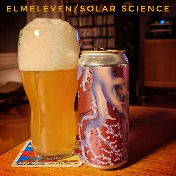 Ölglas med skummande öl bredvid en dekorativ burk med texten "ELMELEVEN/SOLAR SCIENCE".