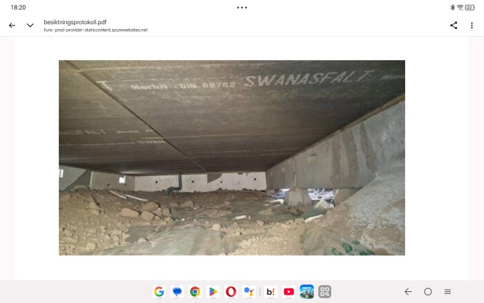 Krypgrund med Asfaboard-skivor märkta "Swanasfalt" ovanpå jordig botten, byggmaterial synligt.