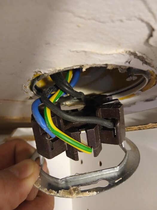 Elektriska kablar med blå, gulgrön och svarta ledningar ses i en upphängning i taket, diskuterar L1/L2/L3 koppling.