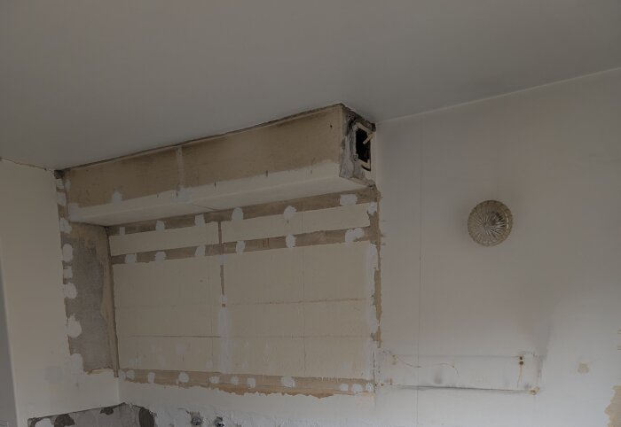 Frånluftskanal i ett kök under renovering, delvis borttagen för att kontrollera eventuellt asbestinnehåll, markerad yta visar där material har avlägsnats.