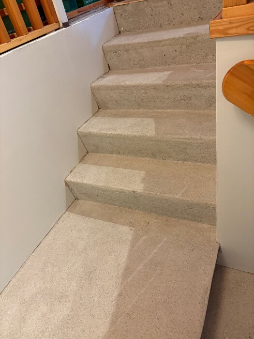 Betongtrappa utan matta, nyligen slipad och fri från lim, redo för behandling för att göra ytan mer slitstark och motståndskraftig mot fläckar.